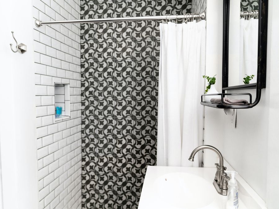 Subway tile shower with a patterned accent wall